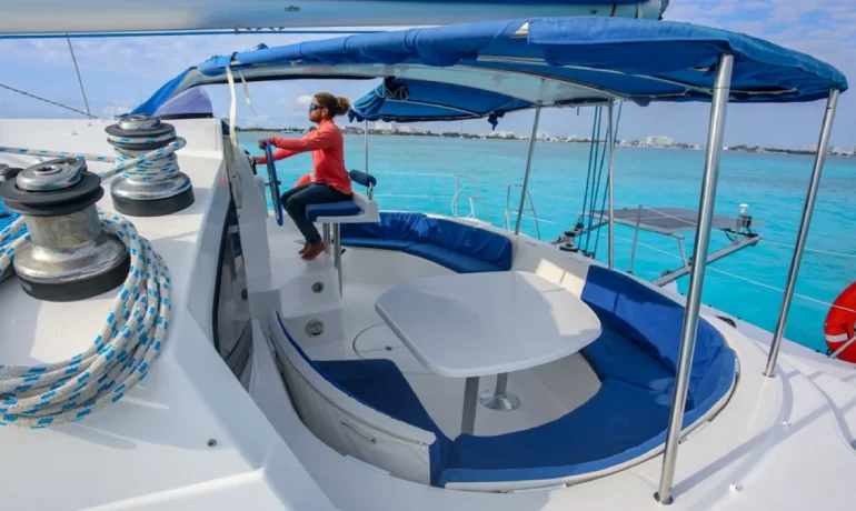 Captain at helm of 4 vents catamaran