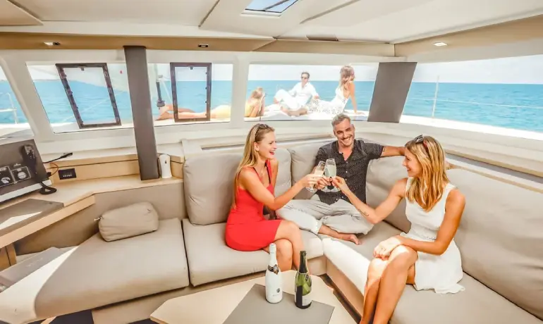 people drinking champagne inside victoria catamaran