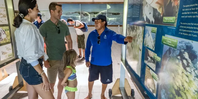 guide with couple looking the museum in isla contoy